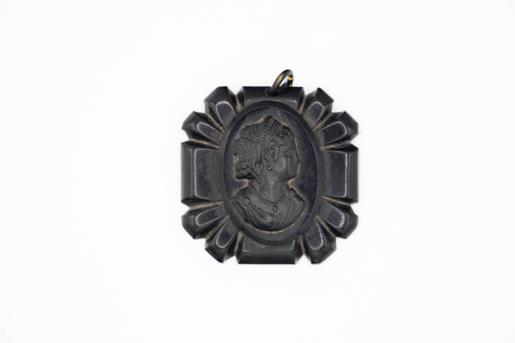 Dark black cameo pendant with the face of a woman.